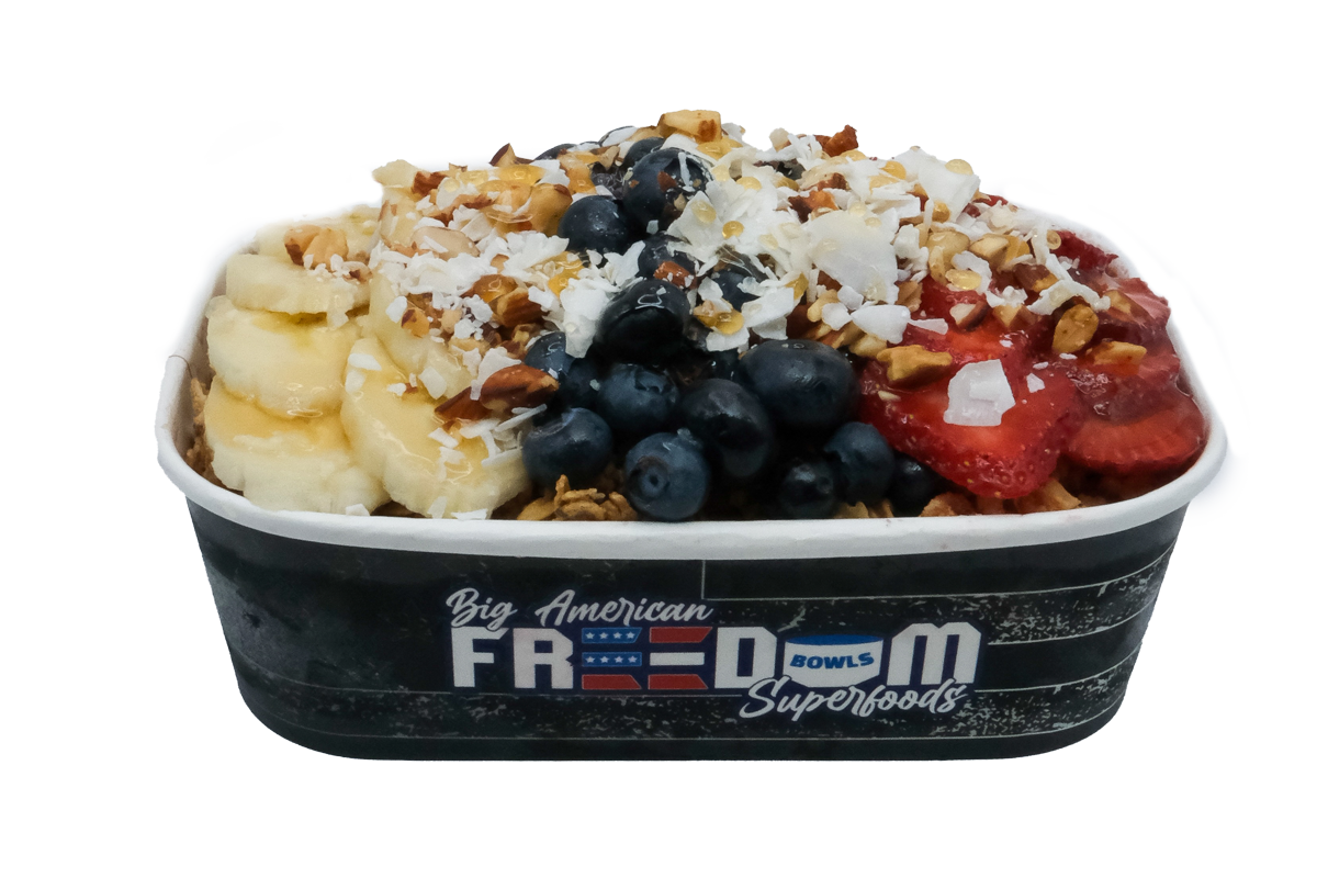 frozen blended creamy coconut base with sliced fresh strawberries, blueberries, and almond granola with honey.